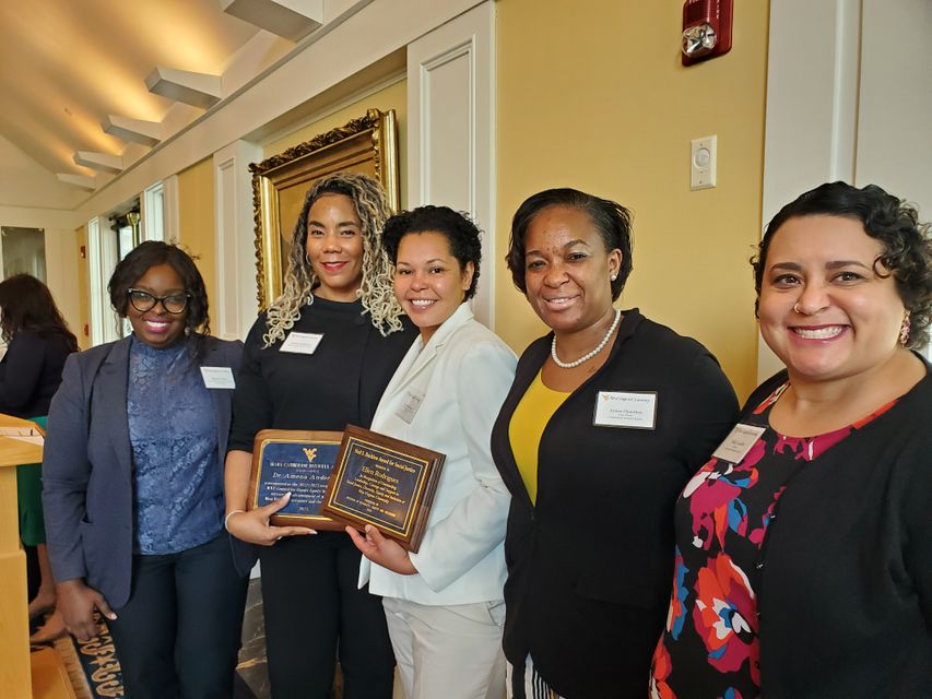 Dr. Amena Anderson holding 2023 Mary Catherine Buswell Award